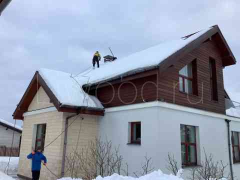 Уборка снега с крыши загородного дома